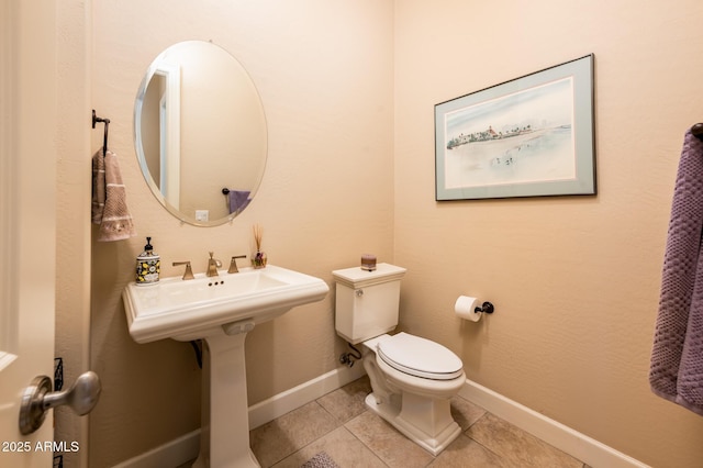 bathroom with toilet, tile patterned flooring, and baseboards