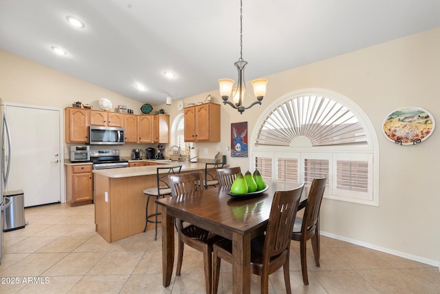 tiled dining area featuring an inviting chandelier, lofted ceiling, and sink