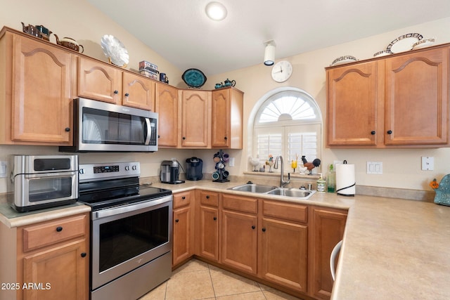 kitchen featuring light tile patterned flooring, stainless steel appliances, and sink