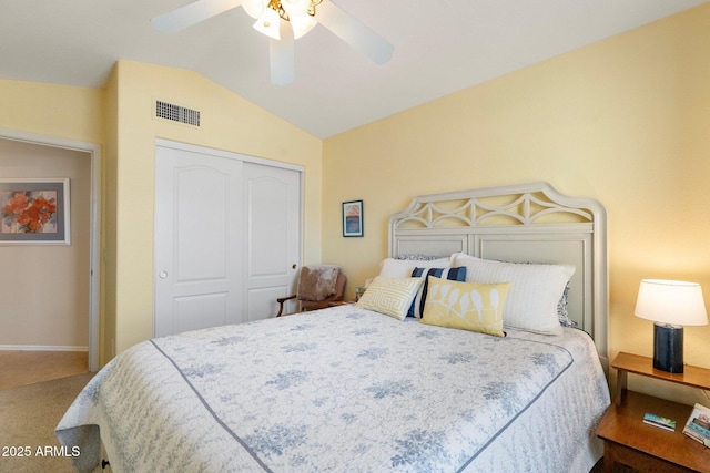 carpeted bedroom with ceiling fan, lofted ceiling, and a closet