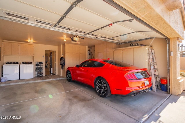 garage with independent washer and dryer, a garage door opener, and water heater