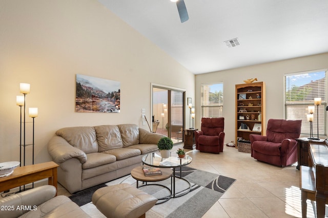 living room with a wealth of natural light, high vaulted ceiling, light tile patterned floors, and ceiling fan