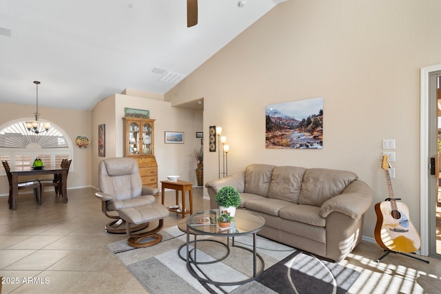 living room featuring light tile patterned flooring, ceiling fan with notable chandelier, and high vaulted ceiling