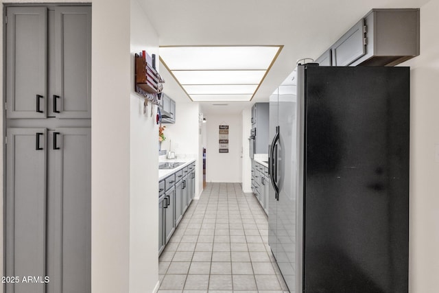 kitchen featuring light tile patterned floors, gray cabinets, and black appliances