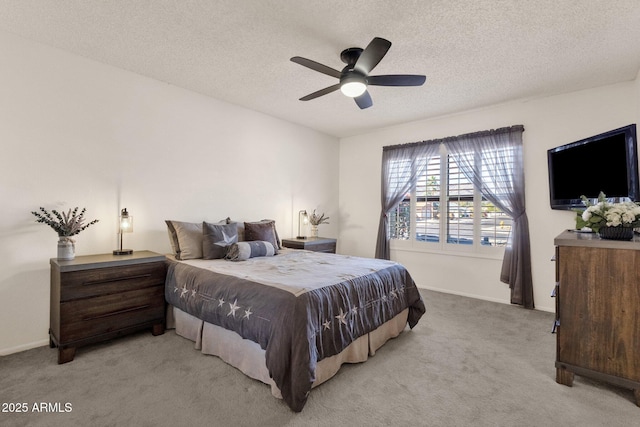 bedroom featuring ceiling fan, light carpet, and a textured ceiling