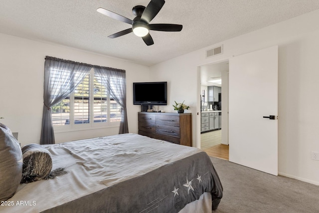 carpeted bedroom with ceiling fan and a textured ceiling