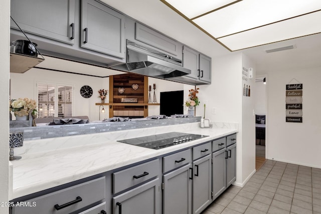 kitchen with light tile patterned flooring, gray cabinetry, and black electric stovetop