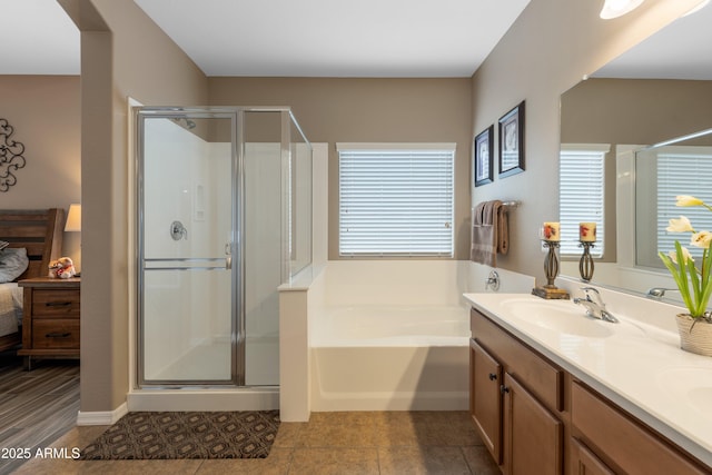 bathroom with independent shower and bath, tile patterned flooring, vanity, and a healthy amount of sunlight