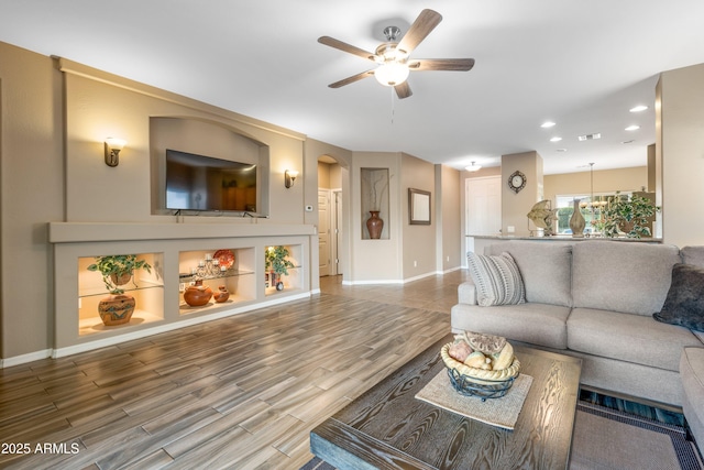 living room featuring ceiling fan and hardwood / wood-style floors