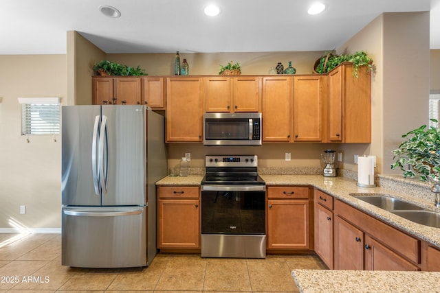 kitchen featuring sink, light stone countertops, stainless steel appliances, and light tile patterned floors