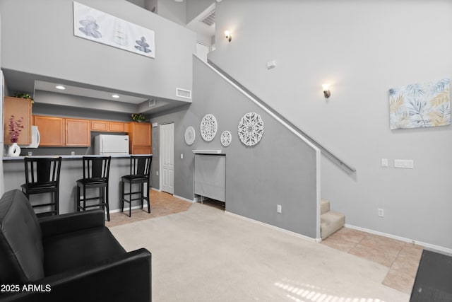 living room featuring stairs, baseboards, light carpet, a towering ceiling, and recessed lighting