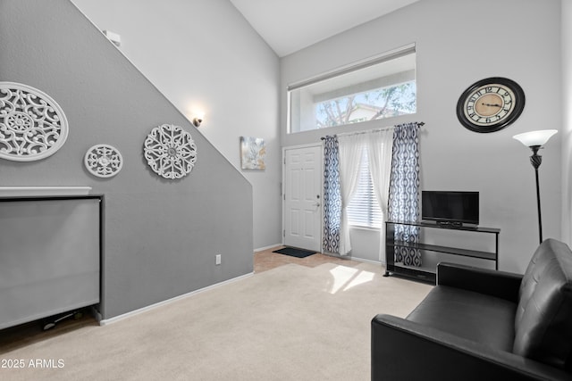 living room with carpet flooring, high vaulted ceiling, and baseboards