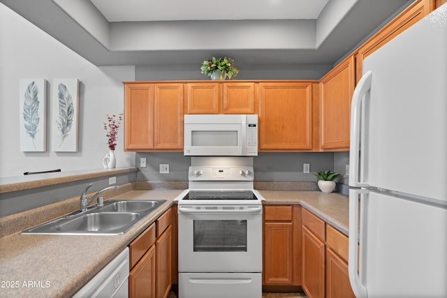 kitchen with white appliances, a sink, and light countertops