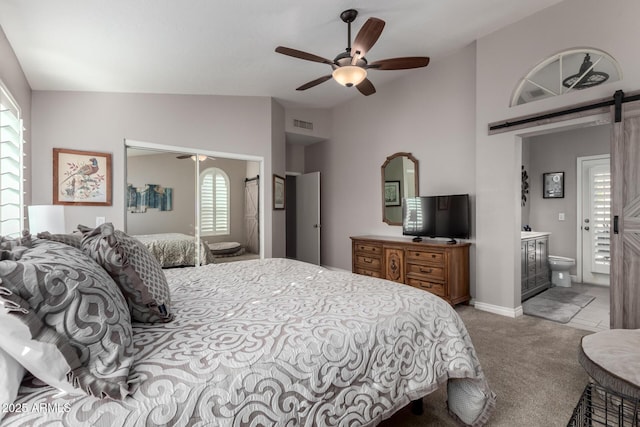 carpeted bedroom with lofted ceiling, ceiling fan, a barn door, and connected bathroom