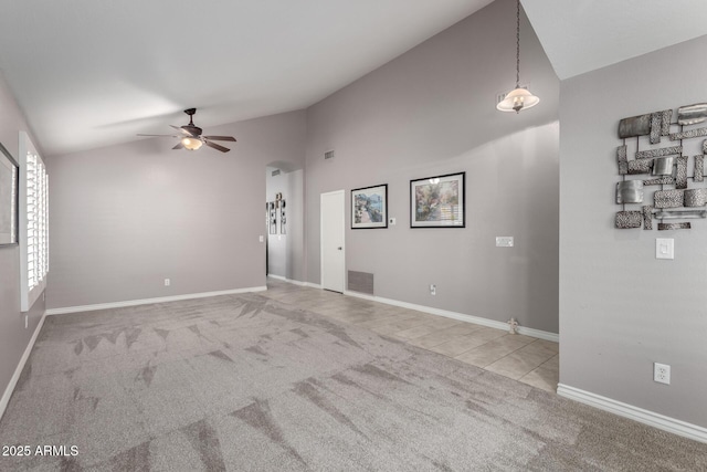 spare room with ceiling fan, vaulted ceiling, and light carpet