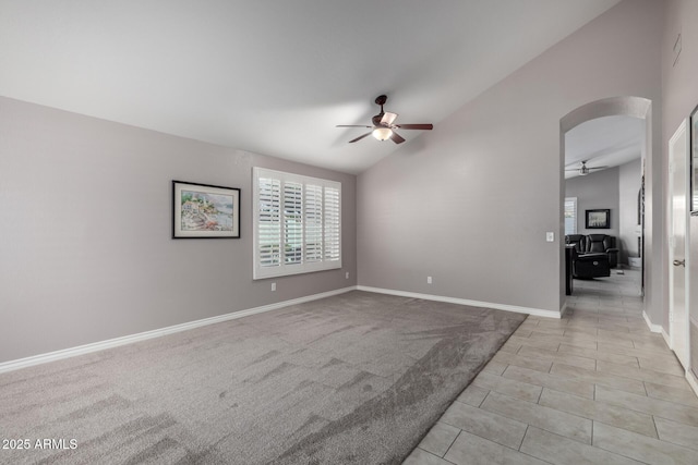 carpeted spare room featuring ceiling fan and lofted ceiling