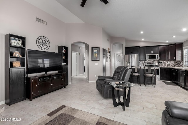 tiled living room featuring lofted ceiling, ceiling fan, and sink