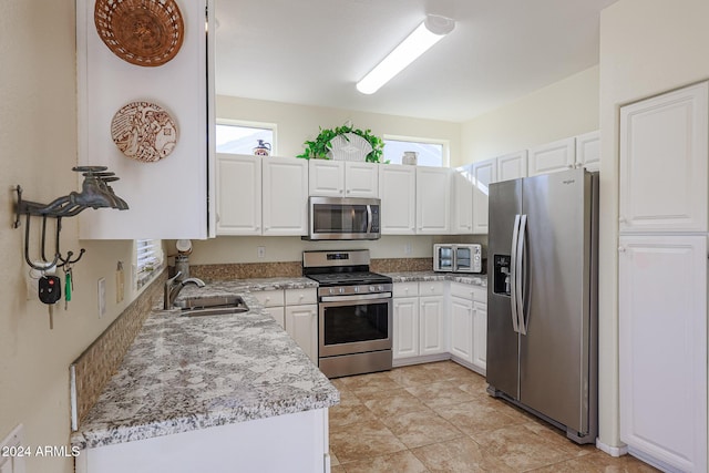 kitchen featuring white cabinetry, a healthy amount of sunlight, sink, and stainless steel appliances