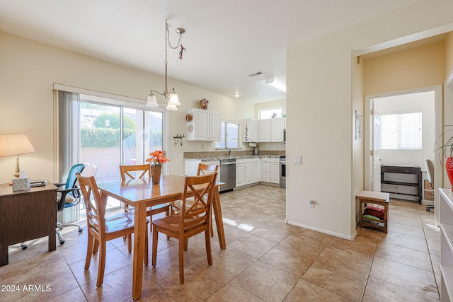 dining room featuring a chandelier, sink, a healthy amount of sunlight, and light tile patterned flooring