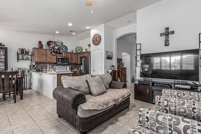 3755 E Hazeltine Way, Chandler, AZ 85249 - living area featuring arched walkways, vaulted ceiling, light tile patterned floors, and ceiling fan