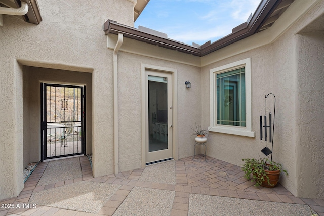 doorway to property featuring a patio and stucco siding