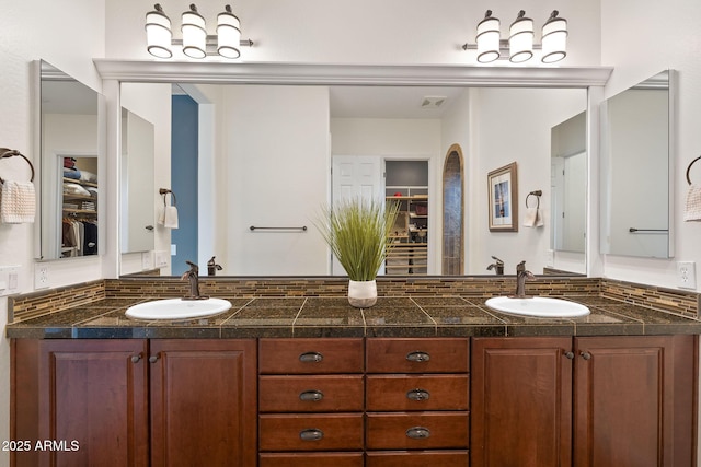 full bathroom with a spacious closet, visible vents, and a sink