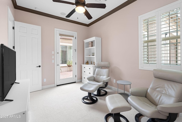 sitting room with carpet flooring, crown molding, and baseboards