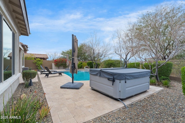 view of patio with a fenced in pool, a fenced backyard, and a hot tub