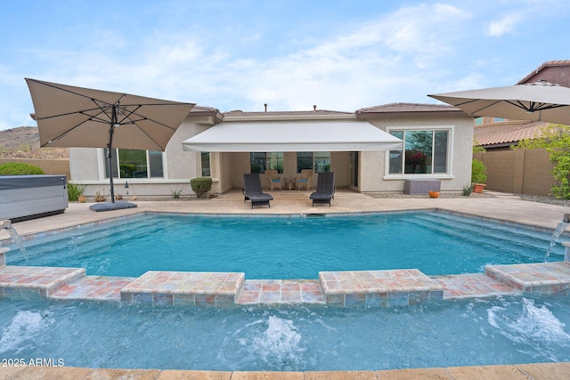 view of pool featuring a pool with connected hot tub, fence, and a patio