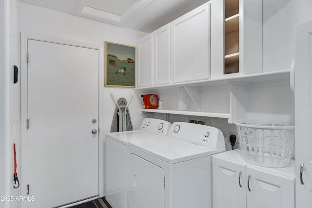 clothes washing area with cabinets and washing machine and dryer