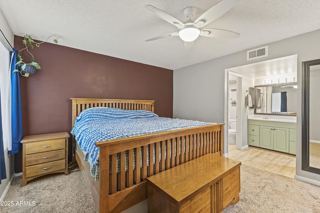 1927 E Hampton Ave Unit 204, Mesa, AZ 85204 - bedroom with a textured ceiling, light colored carpet, ensuite bath, a ceiling fan, and light wood-style floors