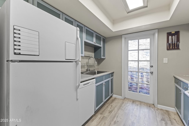 1927 E Hampton Ave Unit 204, Mesa, AZ 85204 - kitchen with white appliances, light wood-type flooring, glass insert cabinets, light countertops, and blue cabinets