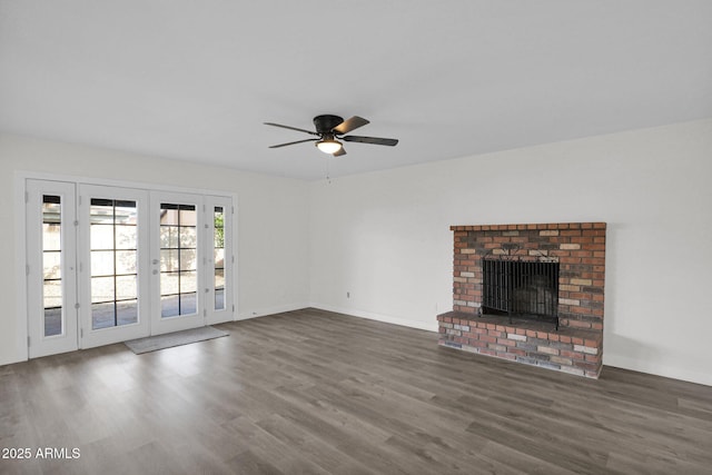 unfurnished living room featuring a fireplace, french doors, ceiling fan, and dark wood-type flooring