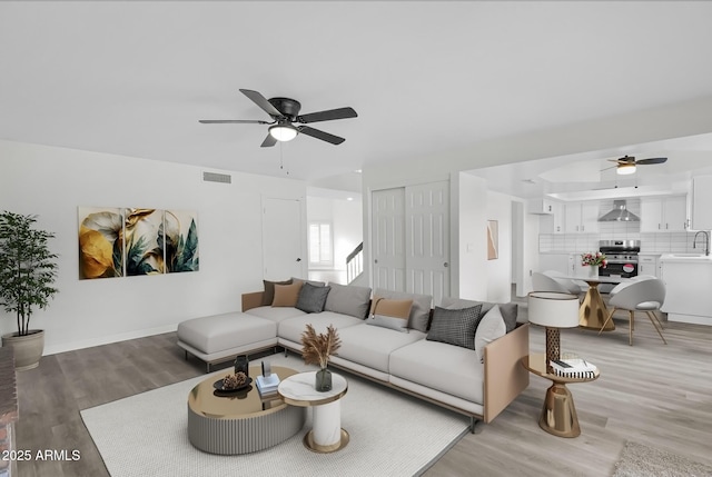 living room with ceiling fan, wood-type flooring, and sink