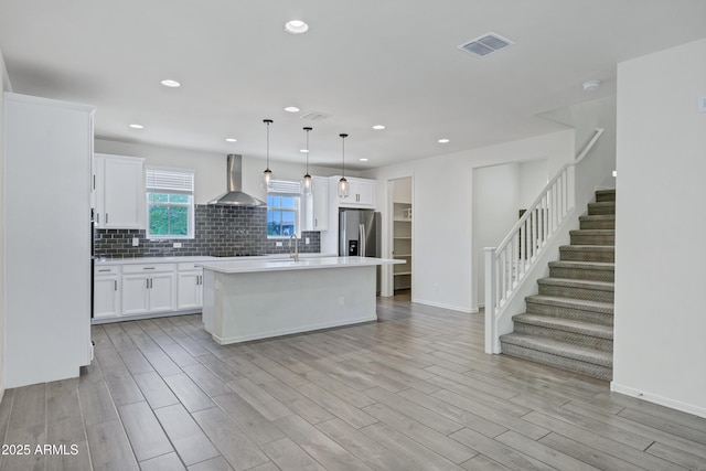 751 W Flintlock Way, Chandler, AZ 85286 - kitchen featuring wall chimney exhaust hood, light countertops, backsplash, white cabinetry, and an island with sink