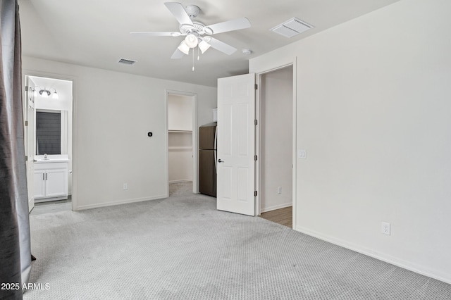 751 W Flintlock Way, Chandler, AZ 85286 - unfurnished bedroom featuring freestanding refrigerator, light colored carpet, a walk in closet, baseboards, and connected bathroom