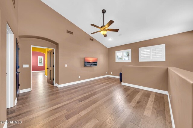 1435 E Rancho Dr, Phoenix, AZ 85014 - unfurnished room featuring ceiling fan, visible vents, arched walkways, high vaulted ceiling, and wood-type flooring