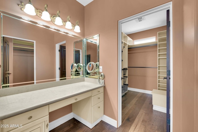 1435 E Rancho Dr, Phoenix, AZ 85014 - bathroom with a spacious closet, vanity, wood finished floors, and visible vents