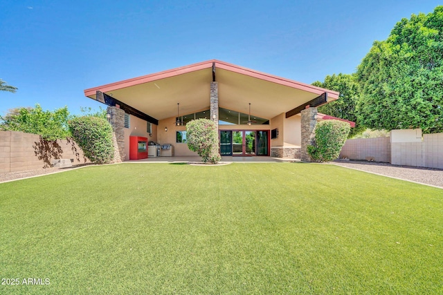 1435 E Rancho Dr, Phoenix, AZ 85014 - back of house featuring ceiling fan, fence, a yard, stone siding, and stucco siding
