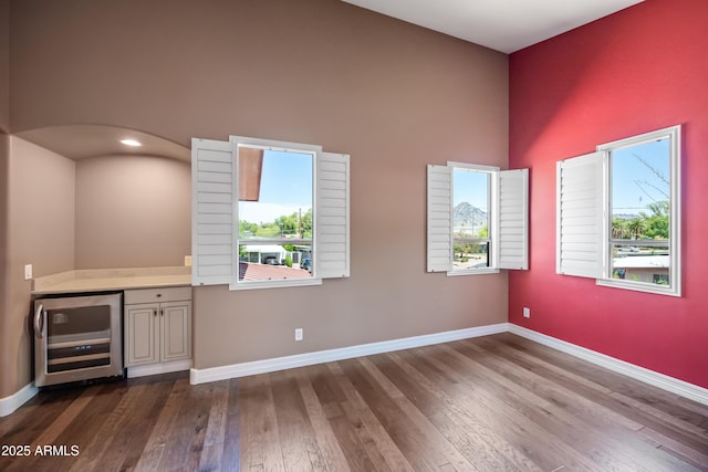 1435 E Rancho Dr, Phoenix, AZ 85014 - bar with beverage cooler, a high ceiling, a healthy amount of sunlight, and dark wood-type flooring