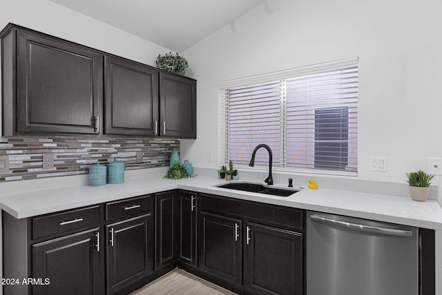 kitchen with dishwasher, sink, light hardwood / wood-style flooring, vaulted ceiling, and tasteful backsplash