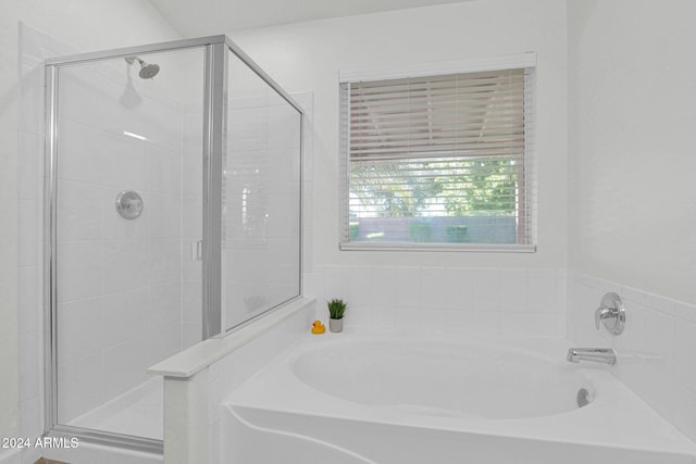 bathroom featuring independent shower and bath