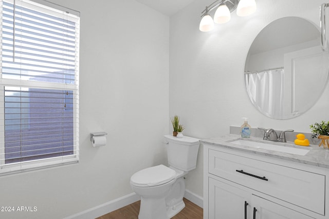 bathroom with hardwood / wood-style flooring, vanity, and toilet