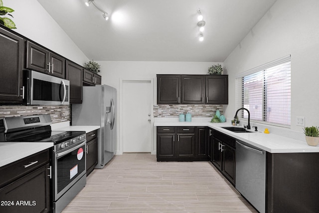 kitchen with tasteful backsplash, sink, vaulted ceiling, and appliances with stainless steel finishes