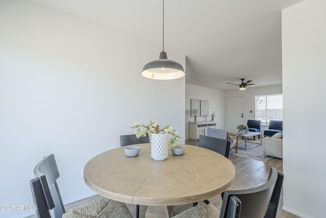 dining area featuring wood finished floors, ceiling fan, and baseboards