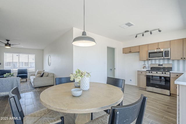 dining room with wood tiled floors, ceiling fan, and baseboards