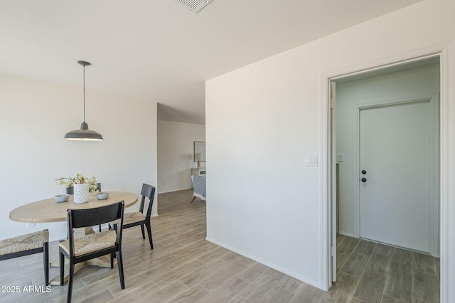 dining space featuring wood finished floors and baseboards