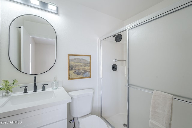 bathroom featuring toilet, a stall shower, and vanity