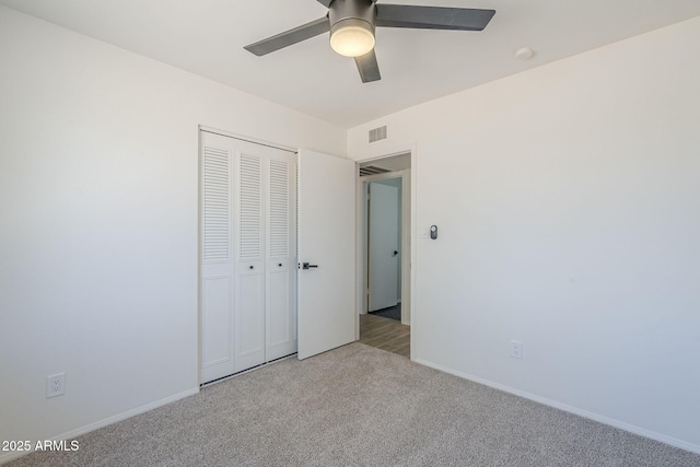 unfurnished bedroom featuring carpet floors, a closet, baseboards, and a ceiling fan