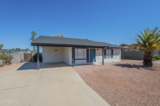 single story home with fence, concrete driveway, and an attached carport